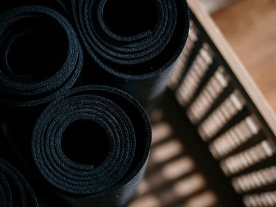 Close up of a rolled yoga mat and water bottle