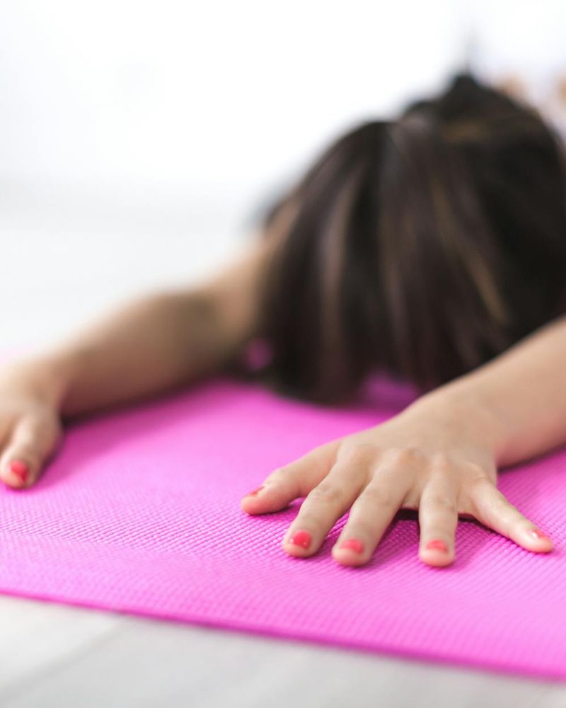 Detail of a yoga mat and a woman's hands in meditation